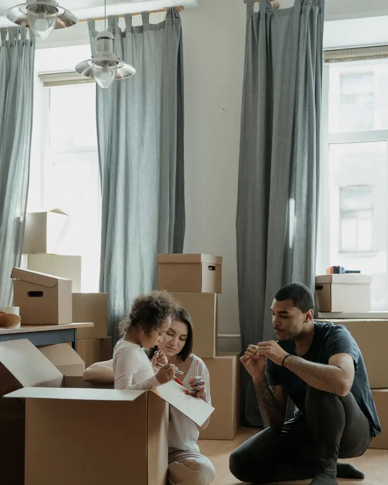 Family smiling together while unpacking boxes in their new kitchen