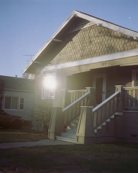 Craftsman bungalow with porch light on at dusk