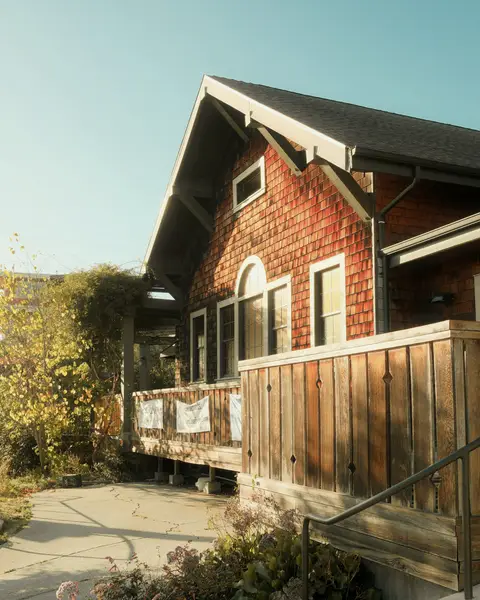 Brick and cedar shingle house with wooden steps