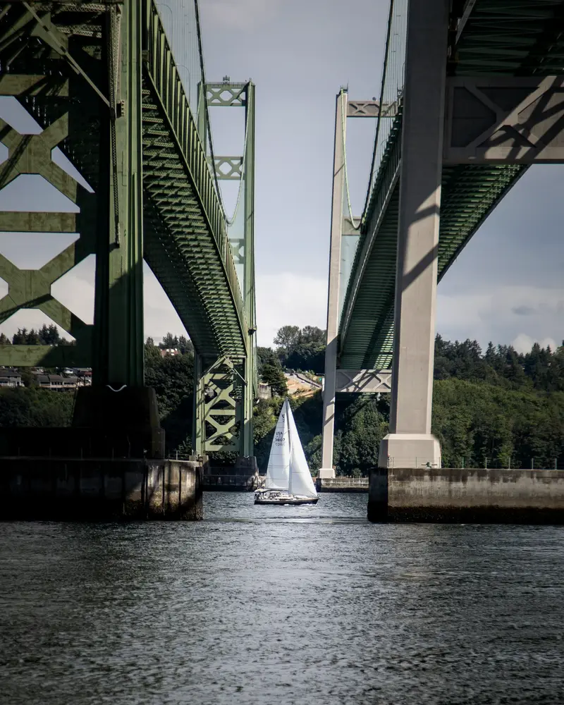 Sailboat passing under the Tacoma Narrows Bridge