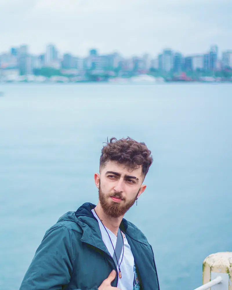 Nate Varga in a teal jacket by the water