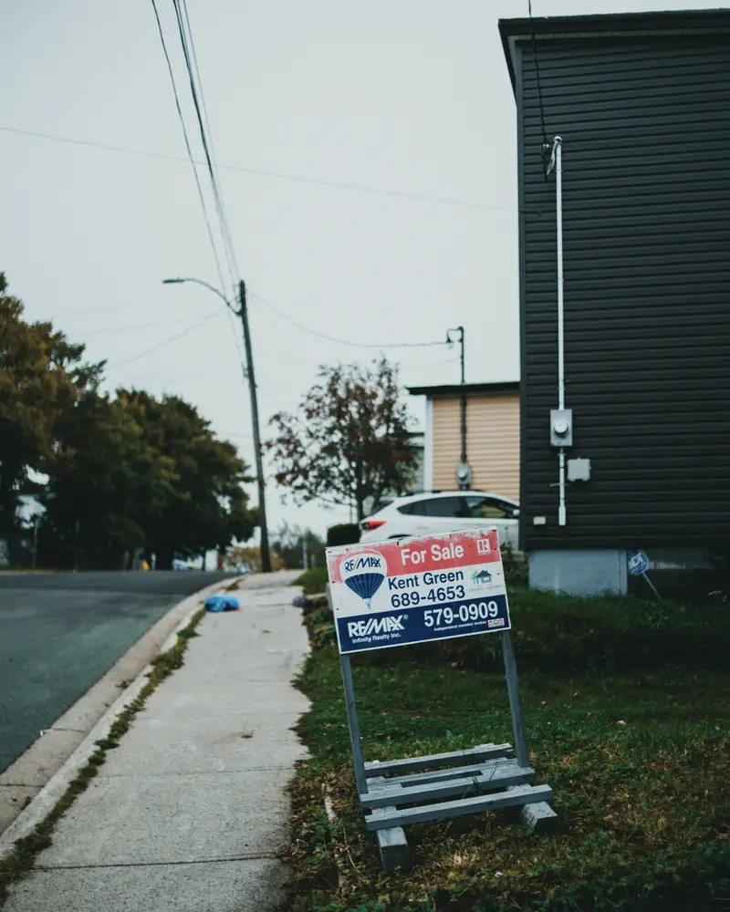 For sale sign on a quiet residential street corner
